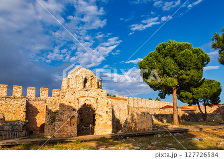 Ancient Byzantine church ruins with arched entrance and fortress wall in Alanya Castle at sunset 127726584