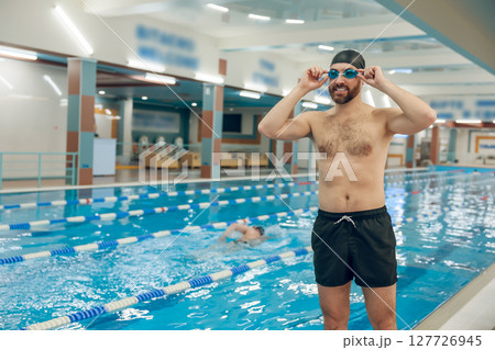 Man having a workout in the swimming pool Man having a workout in the swimming pool 127726945
