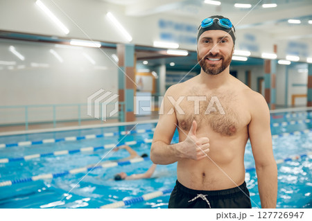 Man having a workout in the swimming pool 127726947