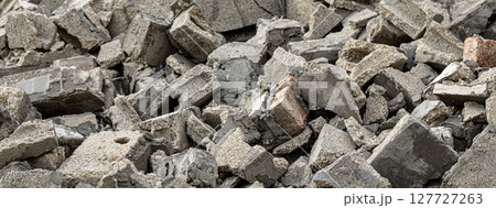 Pile of gray concrete and brick rubble creating textured background 127727263