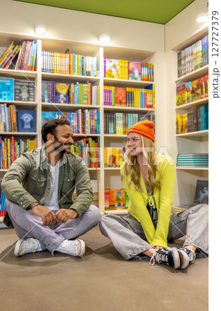 Multicultural man and woman in library together 127727379