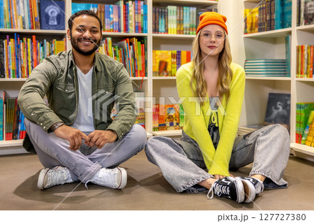 Two friends relaxing in colorful library 127727380