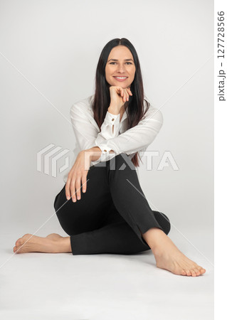 Brunette woman sitting on vintage chair studio portrait 127728566