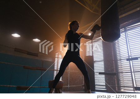Women self defense girl power. Strong woman fighter training punches on boxing ring. Healthy strong girl punching boxing bag. Training day in boxing gym. Strength fit body workout training 127729048