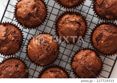 Freshly baked chocolate muffins on a cooling rack. Soft focus Freshly baked chocolate muffins on a cooling rack. Soft focus 127729333