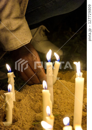 Placing a candle as an offering 127729809