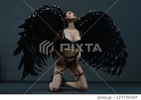 Enchanting woman in lingerie adorned with striking black wings Enchanting woman in lingerie adorned with striking black wings 127730397