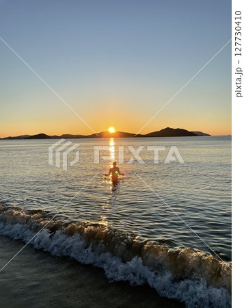 九州の海にて。夕陽と人と波 九州の海にて。夕陽と人と波 127730410