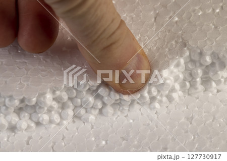 white foam for building insulation , foam made from a large number of pieces joined together, touching the material with your hands 127730917