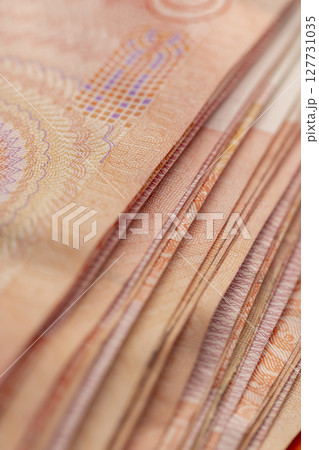 One hundred yuan Chinese money stacked together, large-denomination Red Chinese money stacked together on top 127731035