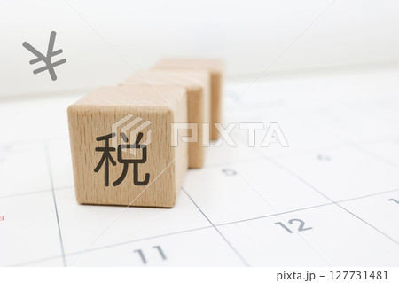 税金の納付期限や確定申告を意識させるカレンダーとブロックの構図 税金の納付期限や確定申告を意識させるカレンダーとブロックの構図 127731481