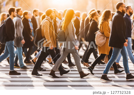 Busy Crowd of Pedestrians Crossing a Street in Bright Sunset Light 127732328
