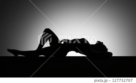 Silhouette of sensual woman lying and posing on a table 127732707
