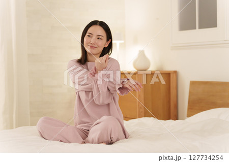 夜ベッドでストレッチする女性 夜ベッドでストレッチする女性 127734254