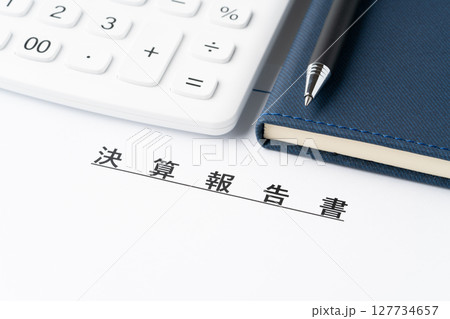 電卓と手帳と決算報告書 127734657