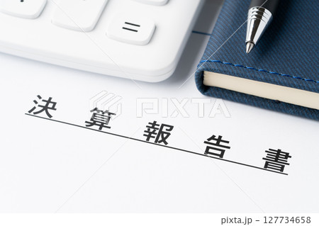 電卓と手帳と決算報告書 127734658