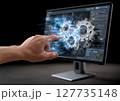 A hand interacts with a computer screen displaying gears and elements of industrial design. The workspace reflects innovation and technological advancement. 127735148