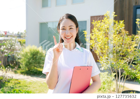 建物の前で微笑む女性看護師 127735632