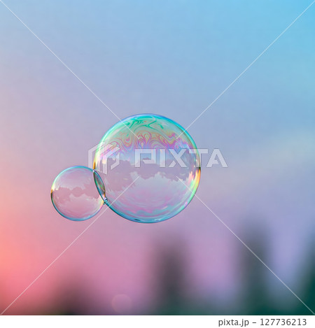 A soft, pastel-toned background with several transparent soap bubbles floating in the air, showcasing iridescent patterns 127736213