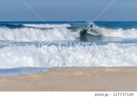 Bodyboarder surfing ocean wave 127737180