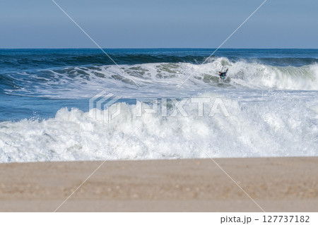 Bodyboarder surfing ocean wave 127737182