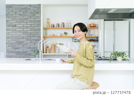 キッチンでタブレットを使うミドルの女性 127737478
