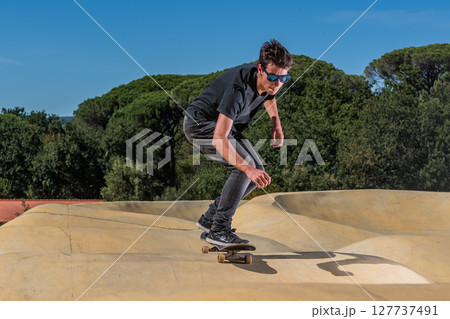 Skateboarder on a pump track park 127737491