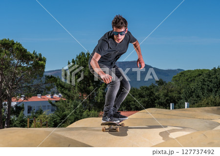 Skateboarder on a pump track park 127737492