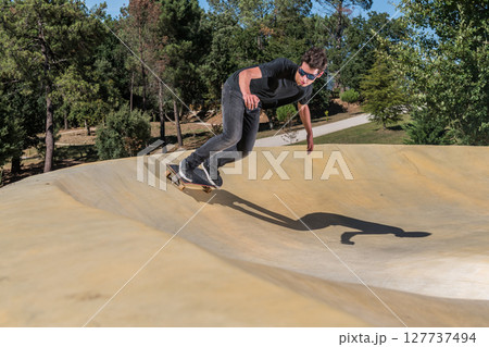 Skateboarder on a pump track park Skateboarder on a pump track park 127737494