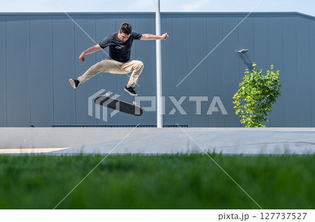 Skateboarder doing a flip trick 127737527