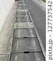 歩道の側溝フタとコンクリートのテクスチャ 127737542