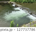 小さな堰を流れる水と白いしぶき 127737786