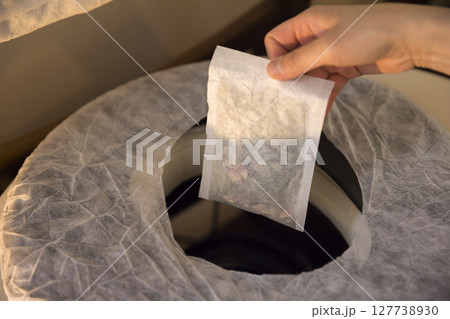 よもぎ蒸しの準備をする女性手元　よもぎパックを持つ女性手元 127738930