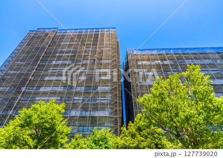 日本の横浜都市景観　マンションの補修や点検等、足場や防護ネットなど。ネットの外に衛星アンテナが… 127739020