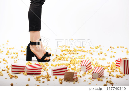 Many popcorn on floor and woman legs background Many popcorn on floor and woman legs background 127740340