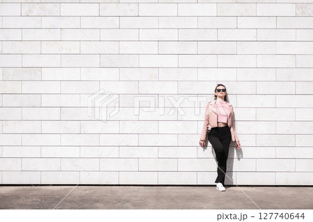 Beautiful woman standing in brick wall background 127740644