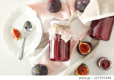 Figs, jars of jam and towel on light background, top view 127741446