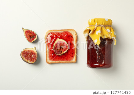Figs, jar of jam and piece of bread on white background, top view Figs, jar of jam and piece of bread on white background, top view 127741450