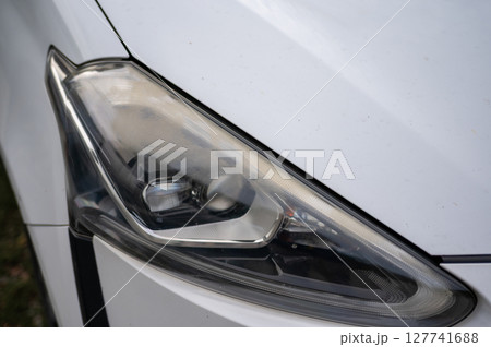Closeup of car headlight with aged or foggy lens Closeup of car headlight with aged or foggy lens 127741688