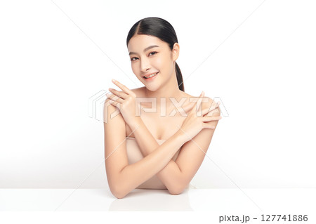A beautiful young Asian woman with clean, fresh skin against a white background. Skincare, facial treatment, cosmetology, beauty, and spa. An elegant portrait of an Asian woman. 127741886