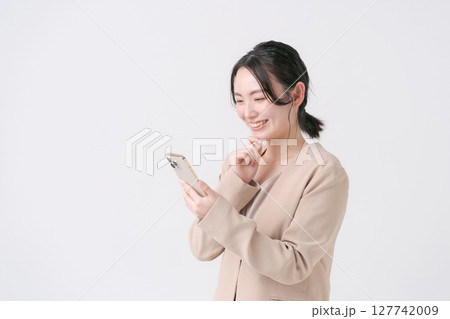 スマホを持つスーツ姿の20代女性 スマホを持つスーツ姿の20代女性 127742009