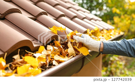 Autumn leaves on the wooden ground and roof, with a closeup of a metal pipe 127742039