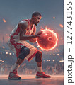 A basketball player in a powerful stance, holding a glowing basketball surrounded by flames, with a dramatic red moon in the background. Motivational concept for basketball enthusiasts. 127743155