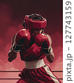 A boxer in full gear, fists raised and ready to punch, with a focused expression under the intense lights of the ring. Motivational concept for boxing enthusiasts. 127743159