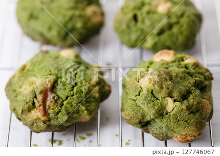 Closeup of fresh baked matcha cookies on white wooden background. Closeup of fresh baked matcha cookies on white wooden background. 127746067