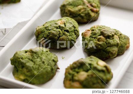 Closeup of fresh baked matcha cookies on white wooden background. Closeup of fresh baked matcha cookies on white wooden background. 127746088