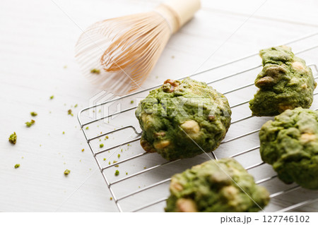 Closeup of fresh baked matcha cookies with Chasen, bamboo whisk, on white wooden background. Closeup of fresh baked matcha cookies with Chasen, bamboo whisk, on white wooden background. 127746102