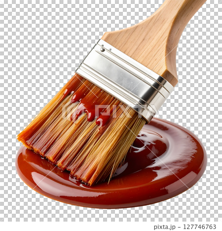 A single artist's paintbrush with a wooden handle and metal ferrule, loaded with vibrant color, stands isolated as an essential tool for painting and creative art work 127746763