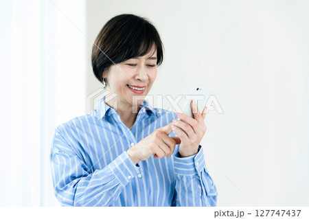 スマホを操作する中高年女性 127747437
