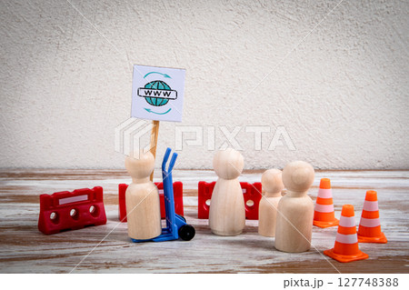 Internet Protest Concept with Wooden Figures Holding WWW Sign Surrounded by Barriers and Cones Internet Protest Concept with Wooden Figures Holding WWW Sign Surrounded by Barriers and Cones 127748388